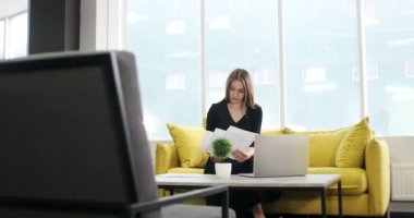 Ofiste çalışan ve düşünen endişeli bir kadın. Defter ve kağıtlarla çalışan çok çekici bir kadın.