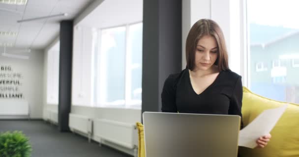 Berörd kvinna arbetar och tänker lösa problem på kontoret. Allvarligt attraktiv kvinna som arbetar med anteckningsbok och papper — Stockvideo