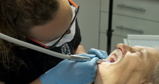 Dentista haciendo tratamiento dental a paciente anciana — Vídeos de Stock