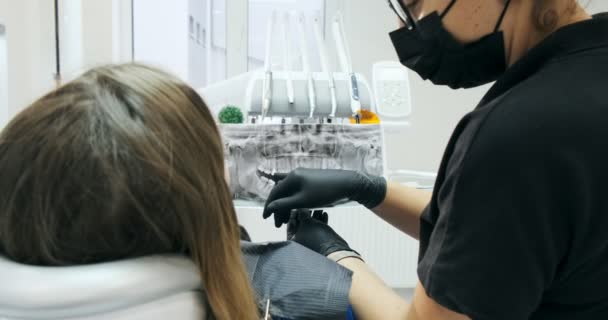 Dentista mostra a jovem mulher seus dentes em raio-x — Vídeo de Stock