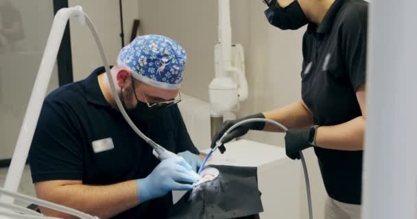 Odontólogos trabajando en la oficina. Dos doctores de un dentista hacen limpieza de dientes de flujo de aire — Vídeos de Stock