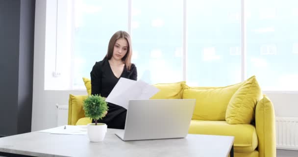 Berörd kvinna arbetar och tänker lösa problem på kontoret. Allvarligt attraktiv kvinna som arbetar med anteckningsbok och papper — Stockvideo