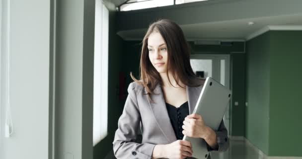 Młoda biznesmenka spacerująca korytarzem biurowym. Poważna atrakcyjna kobieta idzie na konferencję z notatnikiem i papierami — Wideo stockowe
