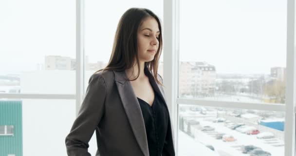 Retrato da empresária que cruza os braços e sorri. Linda executiva feminina de pé perto da janela no escritório — Vídeo de Stock