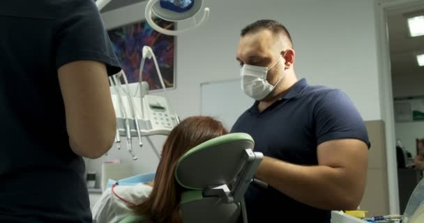 Hombre dentistas trabajando con paciente en el consultorio — Vídeo de stock