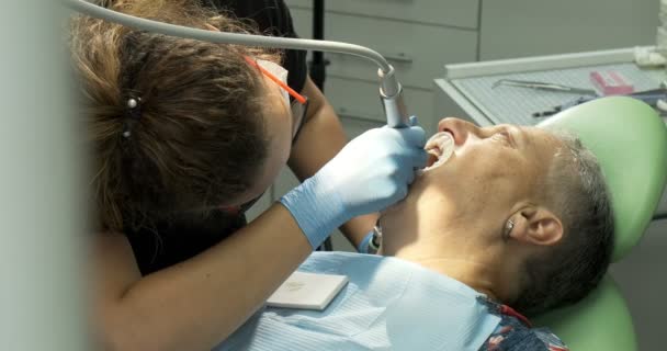 Yaşlı kadın hastaya diş tedavisi uygulayan kadın dişçi — Stok video