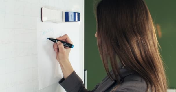 Schöne junge Geschäftsfrau führt finanzielle Berechnungen auf dem Whiteboard durch. Arbeiten mit Papieren weiblich — Stockvideo