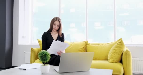 Berörd kvinna arbetar och tänker lösa problem på kontoret. Allvarligt attraktiv kvinna som arbetar med anteckningsbok och papper — Stockvideo