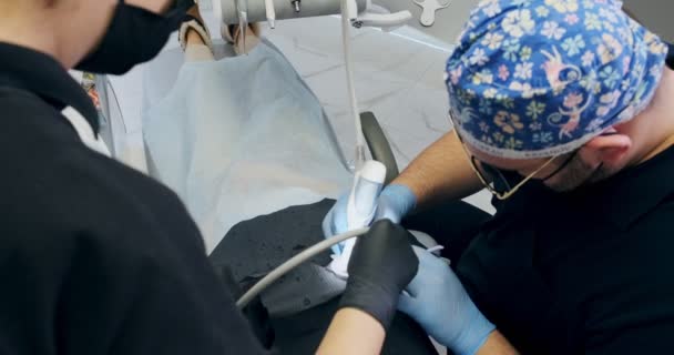 Odontólogos trabajando en la oficina. Dos doctores de un dentista hacen limpieza de dientes de flujo de aire — Vídeos de Stock