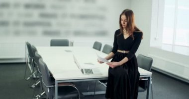 Masada oturan endişeli kadın ofiste çalışır ve sorunu çözmeyi düşünür. Defter ve kağıtlarla çalışan çok çekici bir kadın.