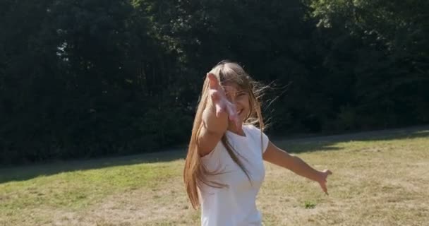 Volg mij, jong vrolijk lachend meisje dat wegrent en je vraagt haar te volgen. Jonge aantrekkelijke vrouw rennen en glimlachen in de zon — Stockvideo