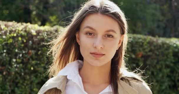 Portrait of young attractive female who smiling and looking at the camera on green historical urban area. Cheerfuly pretty woman. Close up — Stock Video