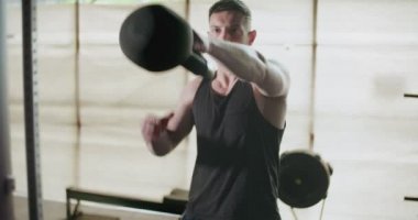 Kettlebells ile antrenman, kapalı spor salonunda yoğun güç egzersizi. Erkekler kettlebell ile idman yapıyor.