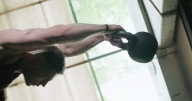 Kettlebells ile antrenman, kapalı spor salonunda yoğun güç egzersizi. Erkekler kettlebell ile idman yapıyor.