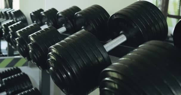 Dumbbells row in modern sport club gym. Close up of sport equipment — Stock Video