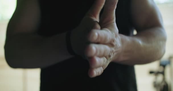 Hombres deportistas preparándose para levantar las manos. Agitar la magnesia de la mano en una habitación oscura antes del entrenamiento — Vídeos de Stock