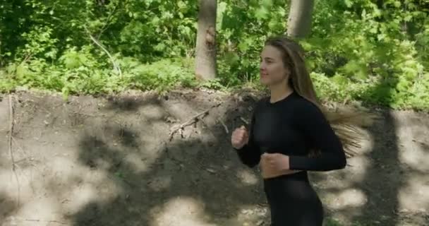 Jonge vrouw runner training in zomerpark. Close-up van fitness vrouw hardlopen in de ochtend buiten — Stockvideo