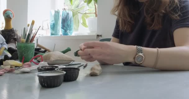 Donna rendendo bambola parte in ceramica da vicino. Femmina seduta e creando orecchio per bambola a casa a tavola. Parti di bambole di ceramica, abilità fatte a mano e creative — Video Stock