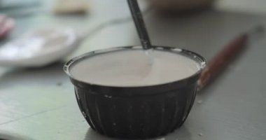 Kadın oyuncak bebek seramiği yapıyor. Kadın evde oturuyor ve masada bebek için kulak yapıyor. Çömlek bebekleri parçaları, el yapımı ve yaratıcı yetenekler