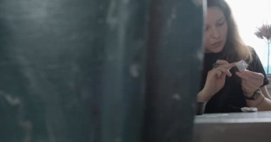 Masada yün oyuncak bebek yapan bir kadın. Kadın evde oturup meşe bebek yapıyor. İğne Keçeli El yapımı ve yaratıcı yetenekler