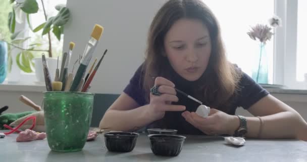 Woman making doll ceramic part. Female sitting and creating ear for doll at home at table. Pottery dolls parts, handmade and creative skills — Stock Video