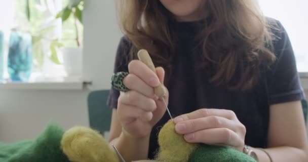 Donna che fa giocattoli bambola di lana a tavola. Donna seduta e creare ooak bambola a casa. Ago feltro Abilità artigianali e creative — Video Stock
