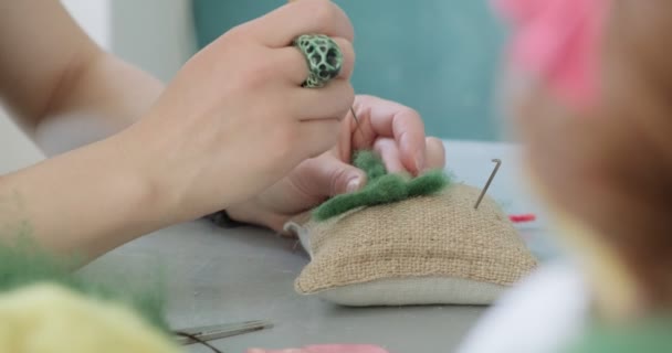 Kvinna gör ull konst docka leksak vid bordet närbild. Kvinnligt sittande och skapande av ekdocka hemma. Nål filtade Handgjorda och kreativa färdigheter — Stockvideo