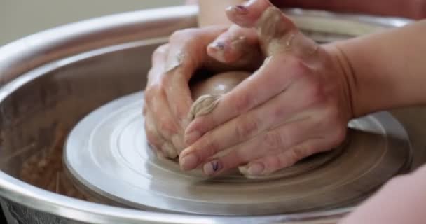 Ceramista donna seduta e fa una tazza sulla ruota ceramica. Donna che fa oggetti in ceramica. Lavorazione della ceramica, abilità artigianali e creative — Video Stock