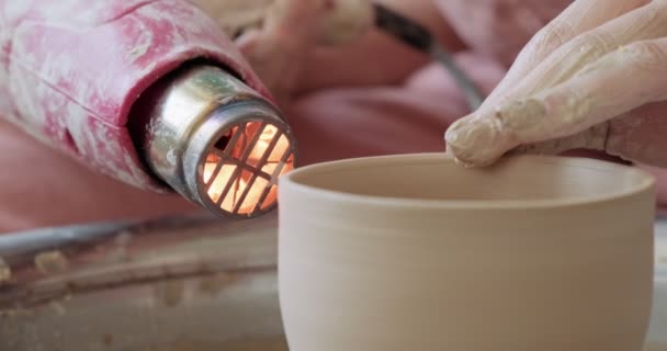 Ceramista femminile seduta e sparare una forma tazza di argilla sulla ruota ceramica. Donna che fa oggetti in ceramica. Cottura della ceramica, abilità artigianali e creative — Video Stock