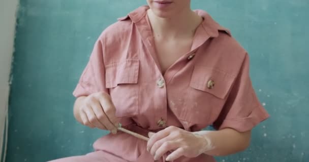 Ceramista donna seduta e fa una tazza sulla ruota ceramica. Donna che fa oggetti in ceramica. Lavorazione della ceramica, abilità artigianali e creative — Video Stock