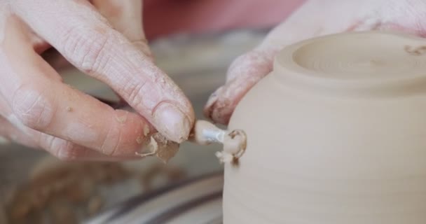 Alfarero hembra sentado y hace una taza en la rueda de cerámica. Mujer haciendo artículo de cerámica. Trabajo de cerámica, habilidades hechas a mano y creativas — Vídeo de stock