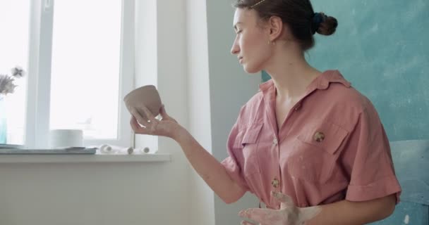 Alfarera sentada y haciendo una taza. Mujer haciendo artículo de cerámica. Trabajo de cerámica, habilidades hechas a mano y creativas — Vídeos de Stock
