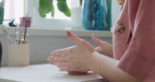 Žena hrnčíř sedí a míchá malovat štětcem pohár na stole. Žena vyrábějící keramické předměty. Pottery working, handmade and creative skills — Stock video