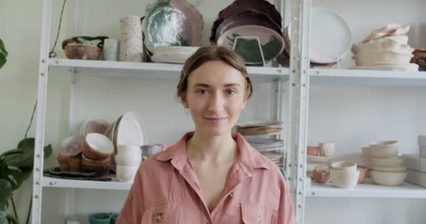 Porträtt av en ung leende attraktiv kvinnlig krukmakare som bor. Keramik arbete, handgjorda och kreativa färdigheter — Stockvideo