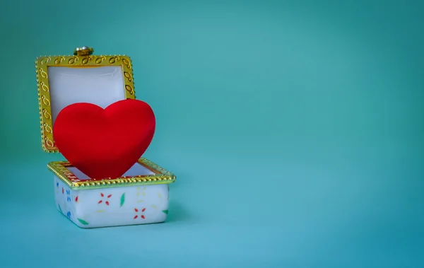 Kotak perhiasan dengan hati di dalamnya dengan latar belakang biru — Stok Foto