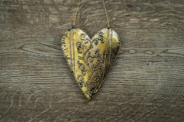 Antika ahşap arka plan üzerinde rustik altın kalp süsleme