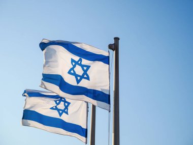 Two national flags of Israel outdoors against the blue sky