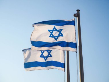 Two national flags of Israel outdoors against the blue sky