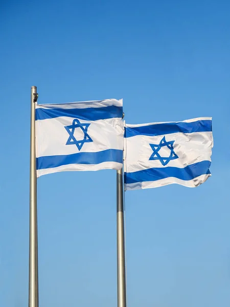 Two national flags of Israel outdoors against the blue sky