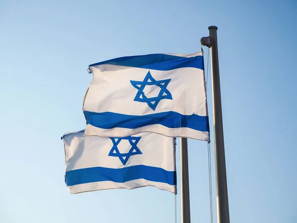Two national flags of Israel outdoors against the blue sky