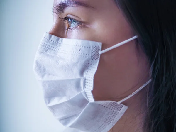 Salgın Koronavirüs. Yüzünde cerrahi maske olan genç bir kadını virüse karşı yakından takip edin..