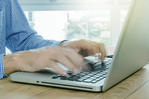 Hombre escribiendo en el ordenador portátil en movimiento borroso . — Foto de Stock