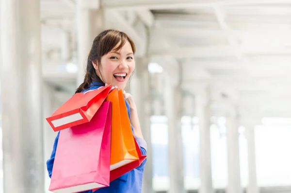 Mooie jonge vrouw van Azië met shopping tassen. — Stockfoto