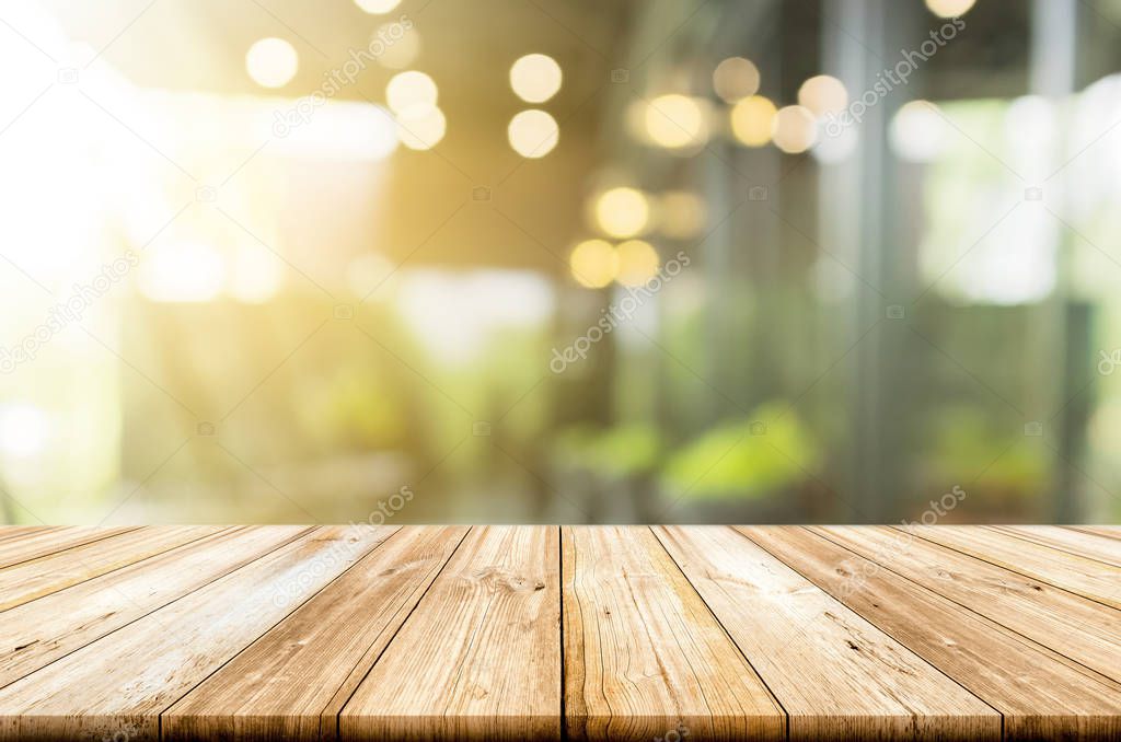 Empty light wood table top with blurred in coffee shop backgroun