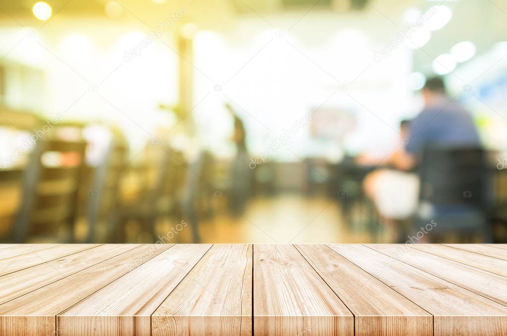 Empty wooden table top with blurred coffee shop interior backgro