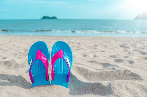 Infradito colorate sulla spiaggia contro il cielo soleggiato . — Foto Stock