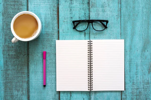 Blue wooden desk table with notebook, color pen, eyeglasses and — Stock Photo, Image