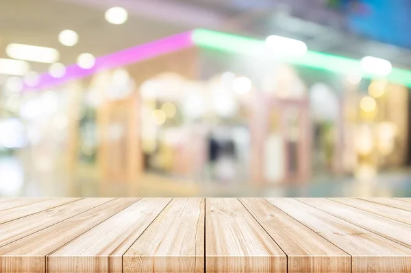 Prázdnou dřevěný stůl top s rozmazané moderní nákupní centrum backgro — Stock fotografie