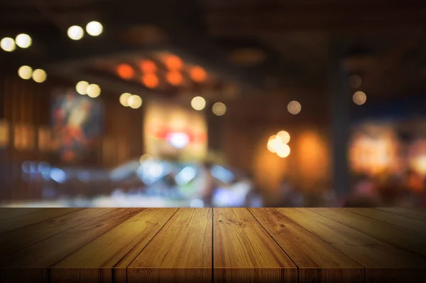 Empty wooden table top with blurred restaurant. — Stock Photo, Image