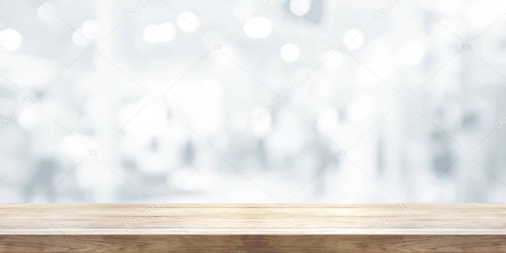 Empty wooden table top with blurred abstract background.